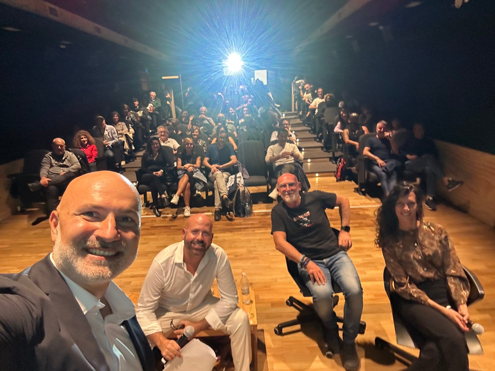 Selfie dal palco del Cineporto di Lecce: i relatori di Epic Routes Community e la sala piena per la presentazione di Sotto il velo del Karma