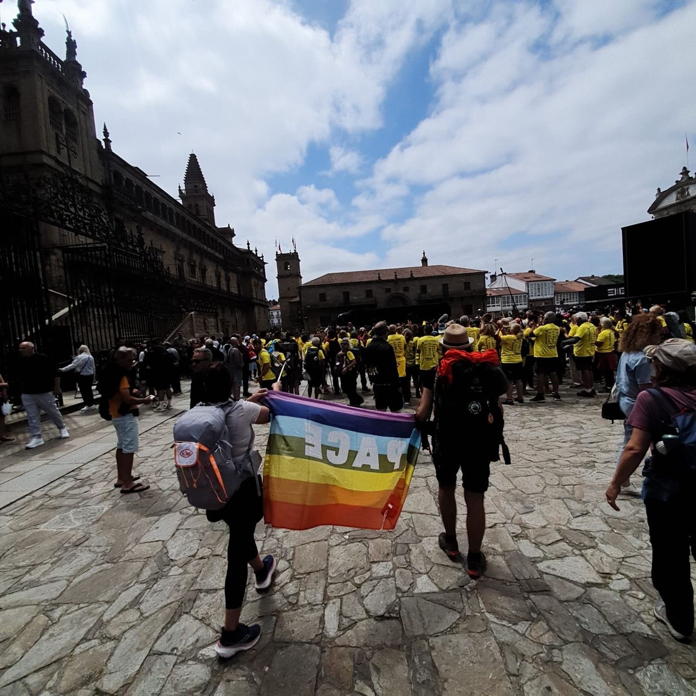 Due pellegrini con la bandiera della pace arrivano in Plaza del Obradoiro, davanti alla cattedrale di Santiago de Compostela