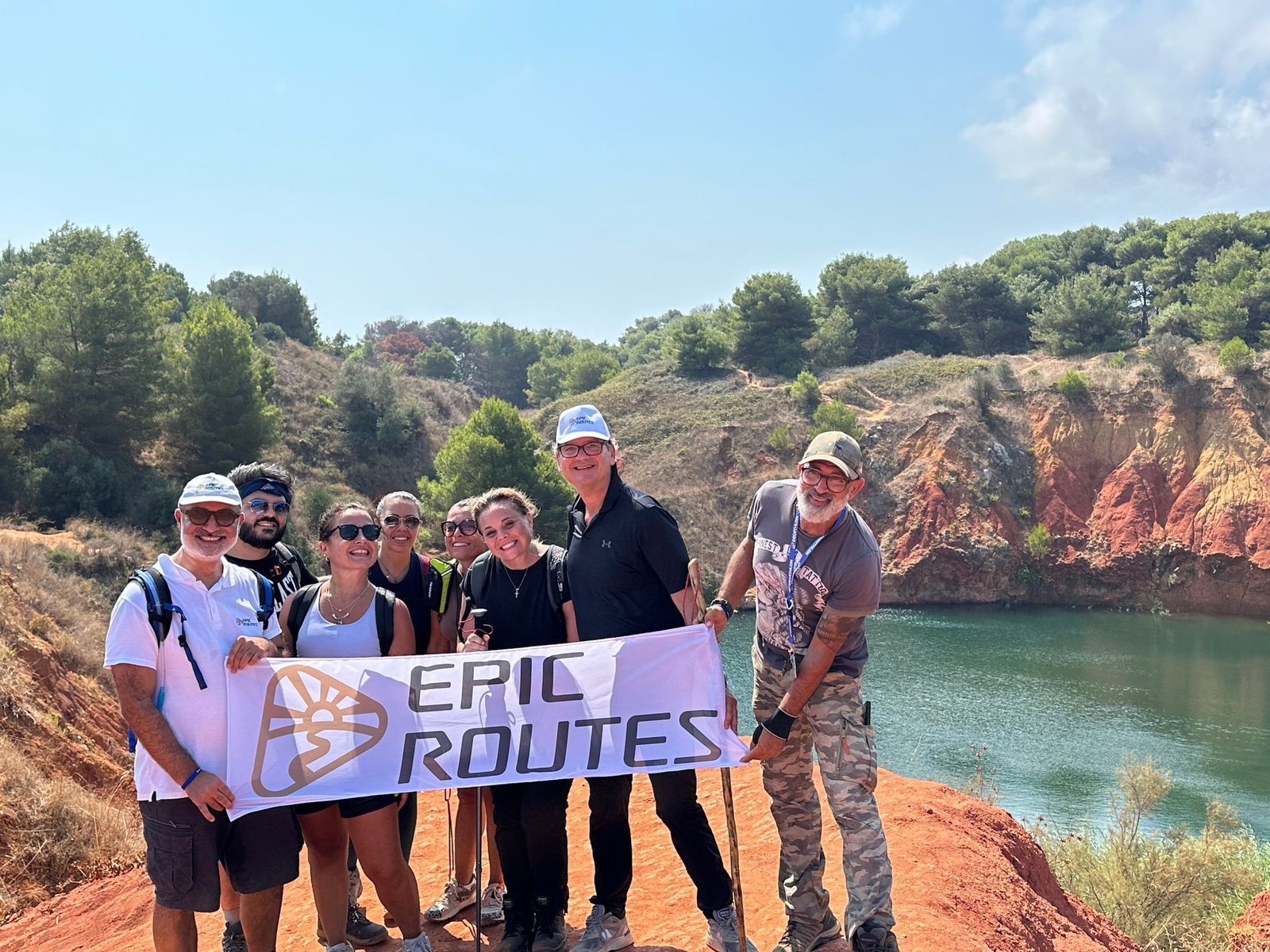 La community di Epic Routes durante uno dei suoi eventi outdoor: trekking alla Cava di Bauxite di Otranto con lo striscione Epic Routes