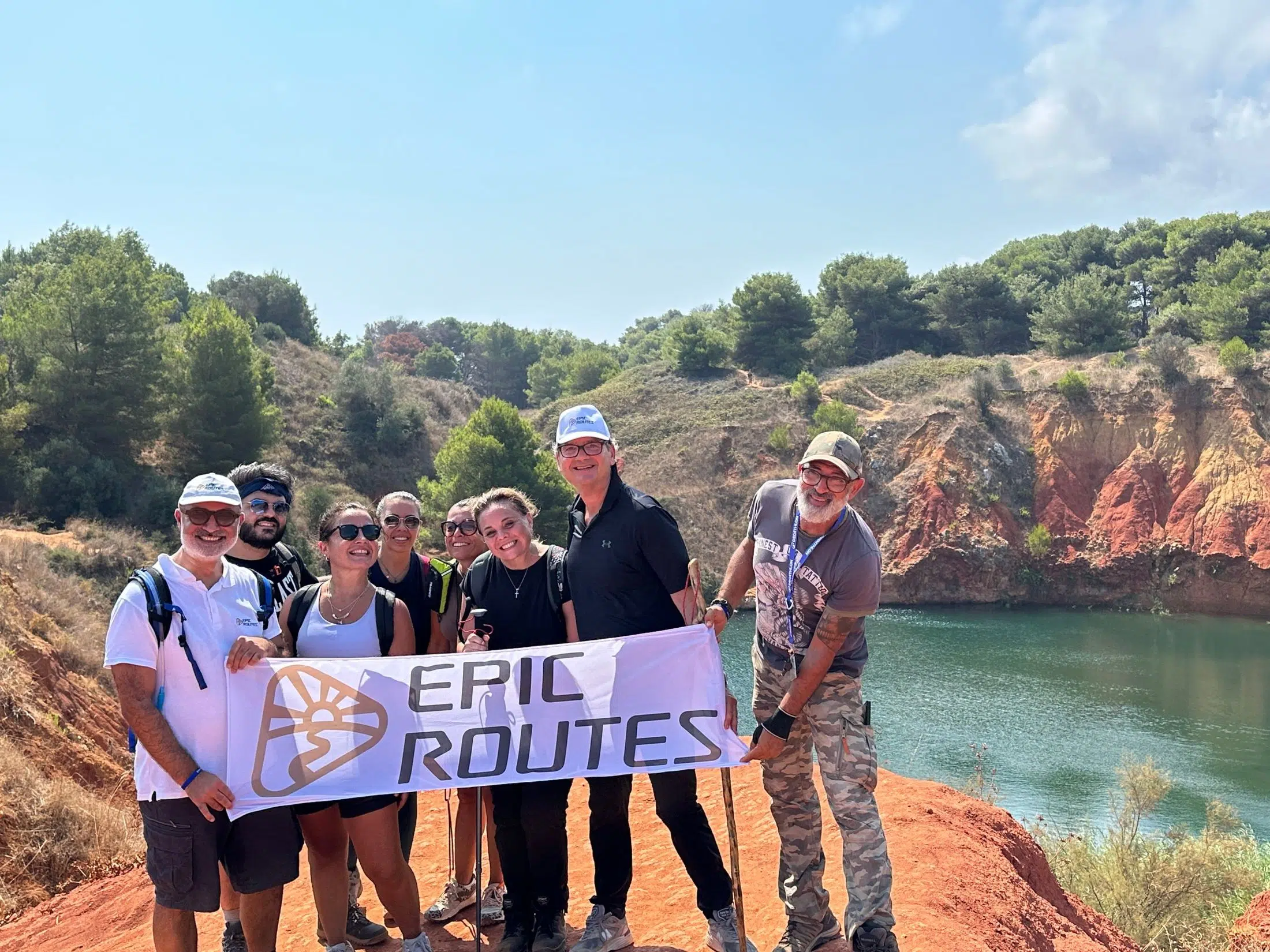 La community di Epic Routes durante uno dei suoi eventi outdoor: trekking alla Cava di Bauxite di Otranto con lo striscione Epic Routes