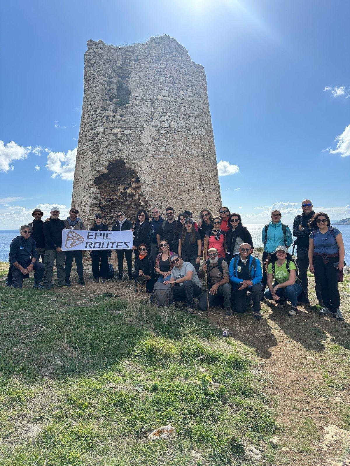 Il gruppo di Epic Routes Community con lo striscione davanti alla Torre Sant'Emiliano, sul mare di Otranto