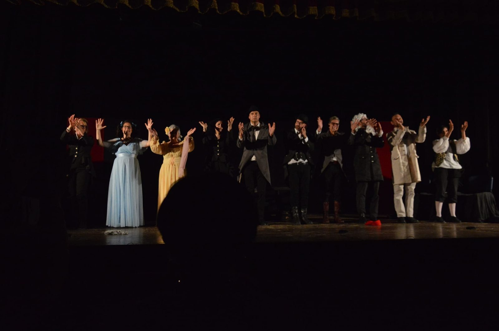Gli attori del Gruppo Teatroadunpasso, Compagnia Teatrale di Epic Routes Community, applaudono il pubblico sul palco al termine de L'ispettore generale di Gogol'