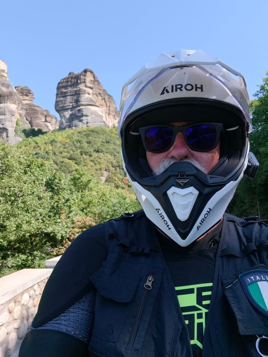 Massimo Pili, Epic Router del Capitolo di Lecce, con casco da moto e occhiali da sole davanti alle rocce delle Meteore, in Grecia