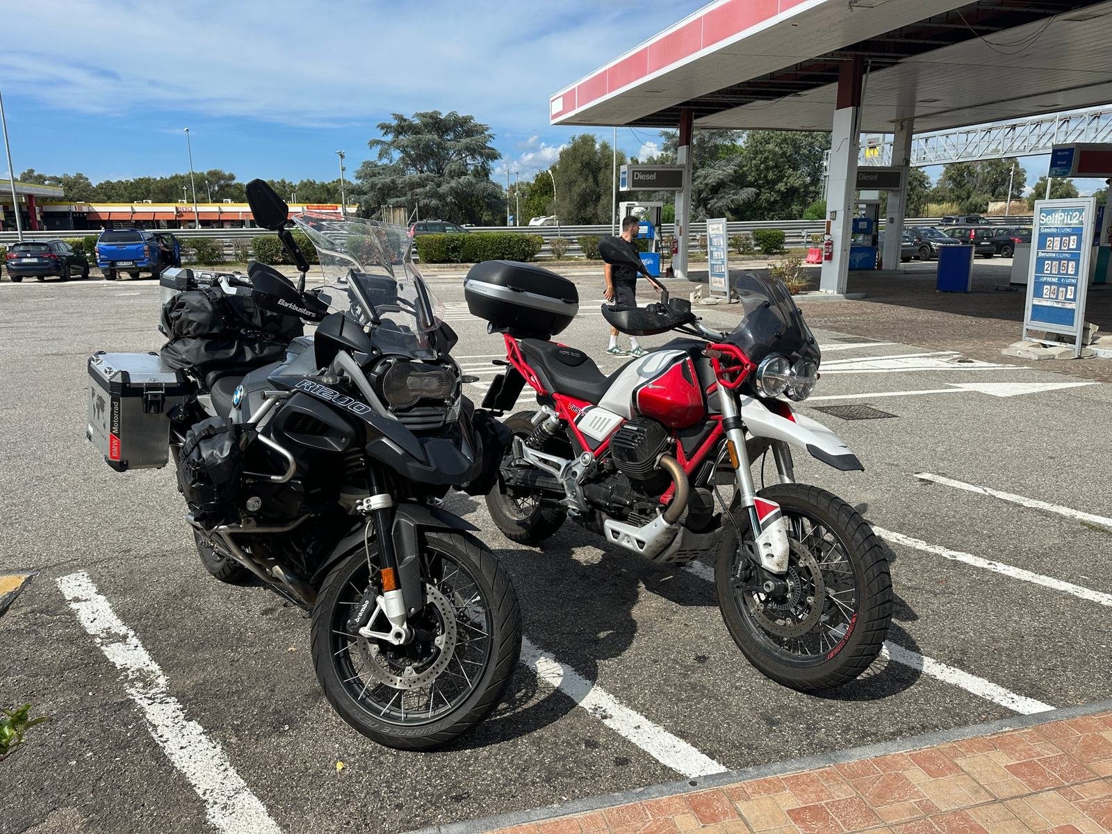 Una BMW R1200 GS Adventure e una Moto Guzzi V85 TT ferme in un'area di servizio durante il viaggio in moto da Lecce alla Sicilia
