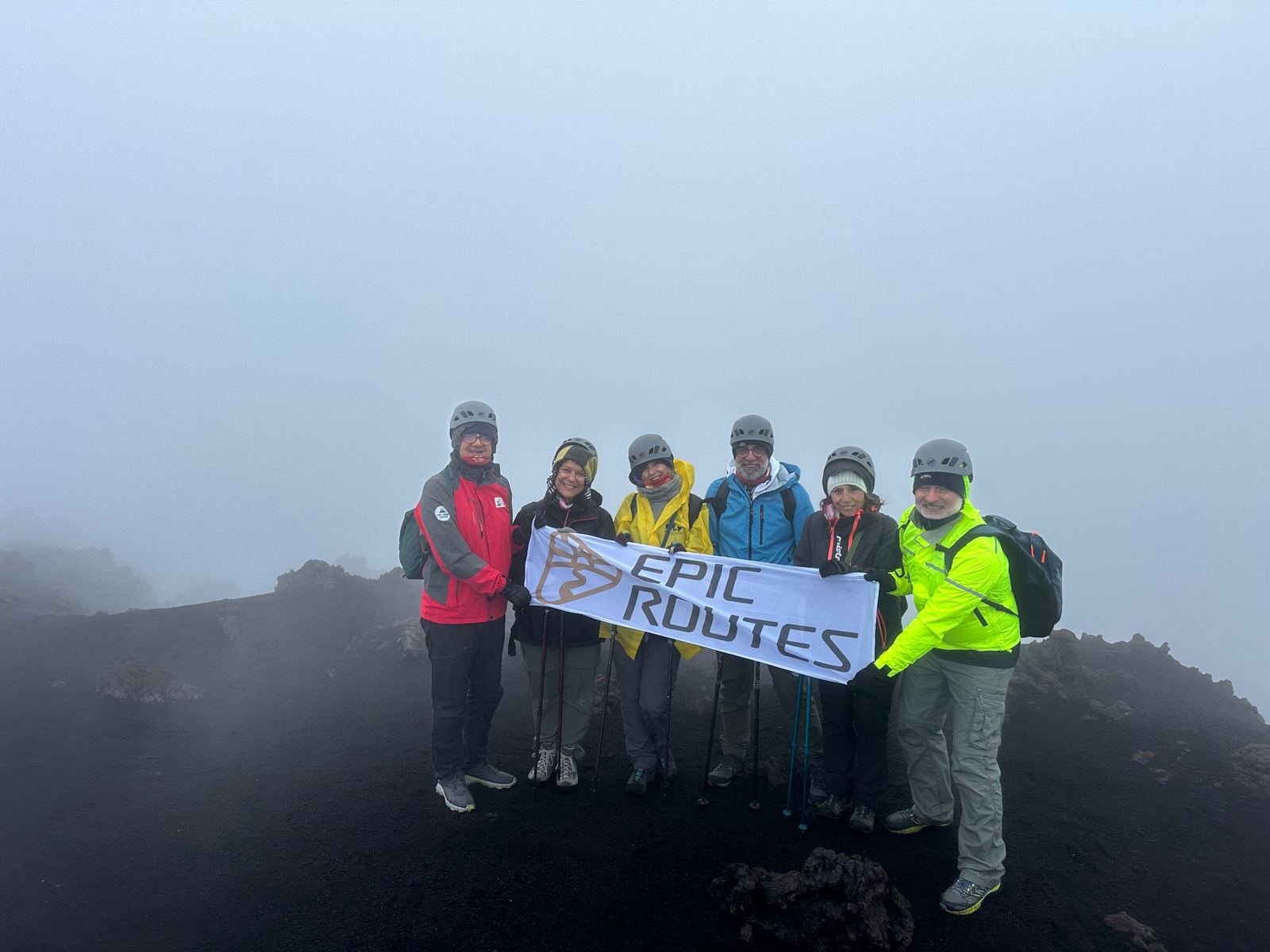 Il gruppo di Epic Routes Community con lo striscione ai crateri sommitali dell'Etna, nella nebbia
