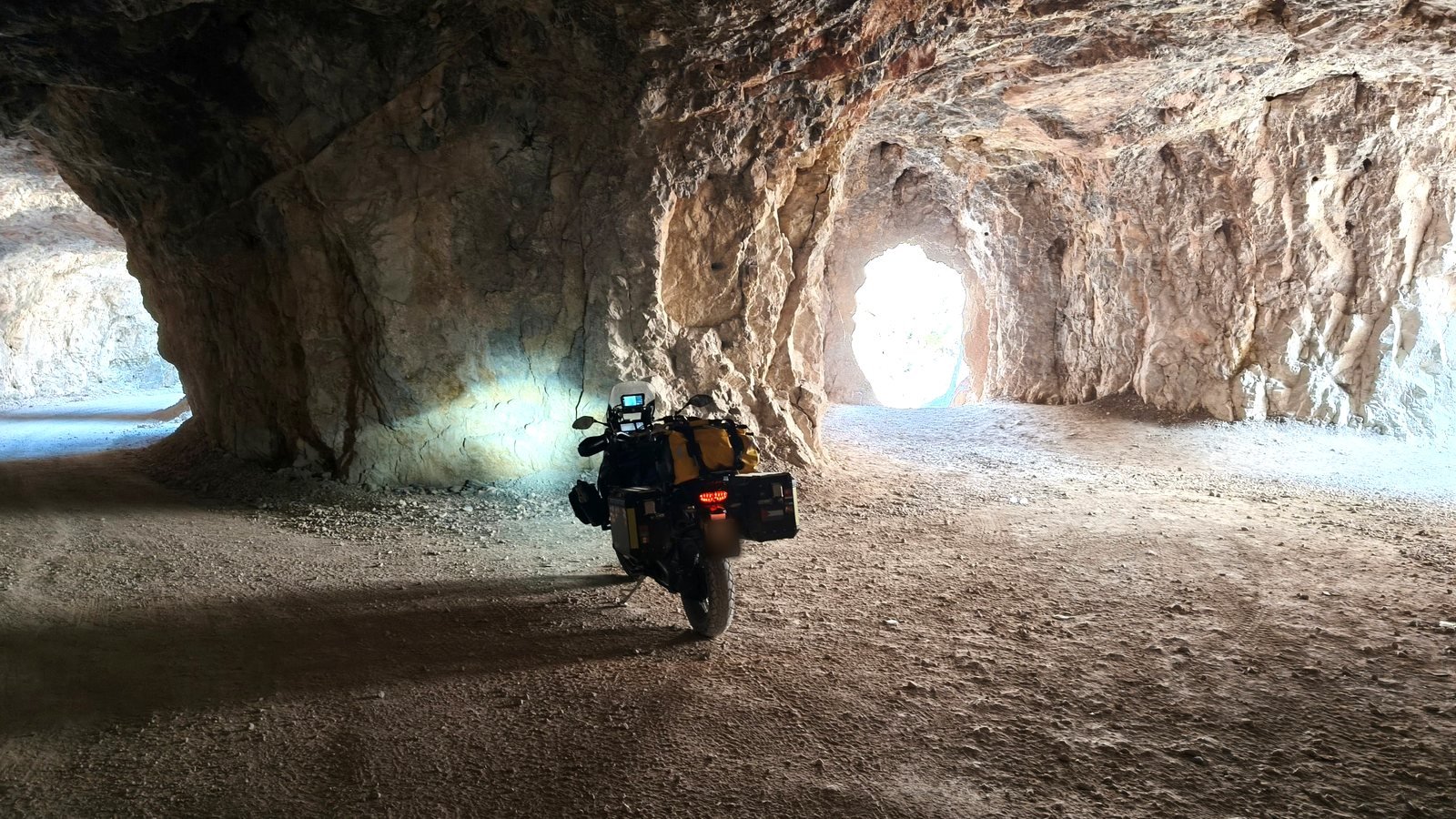 Moto da viaggio con borse laterali ferma dentro una galleria scavata nella roccia del Dark Canyon di Kemaliye, in Turchia
